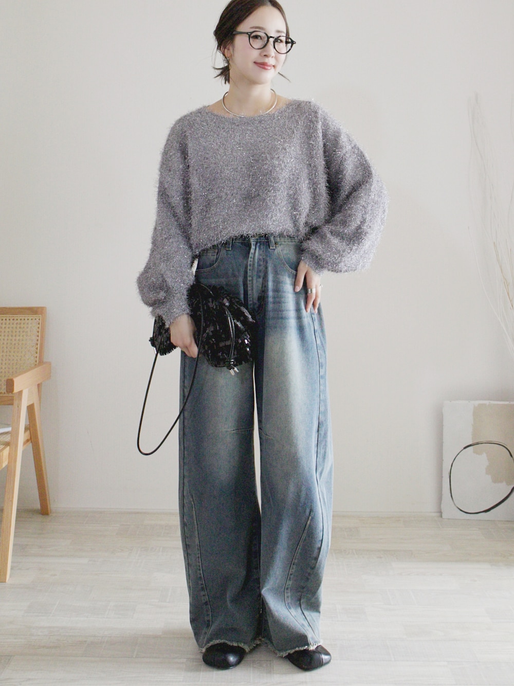 ブルー系のデニムパンツ、グレー系のニット/セーター、ブラック系のサンダルを着用したレディースの秋コーディネートの1枚目の写真