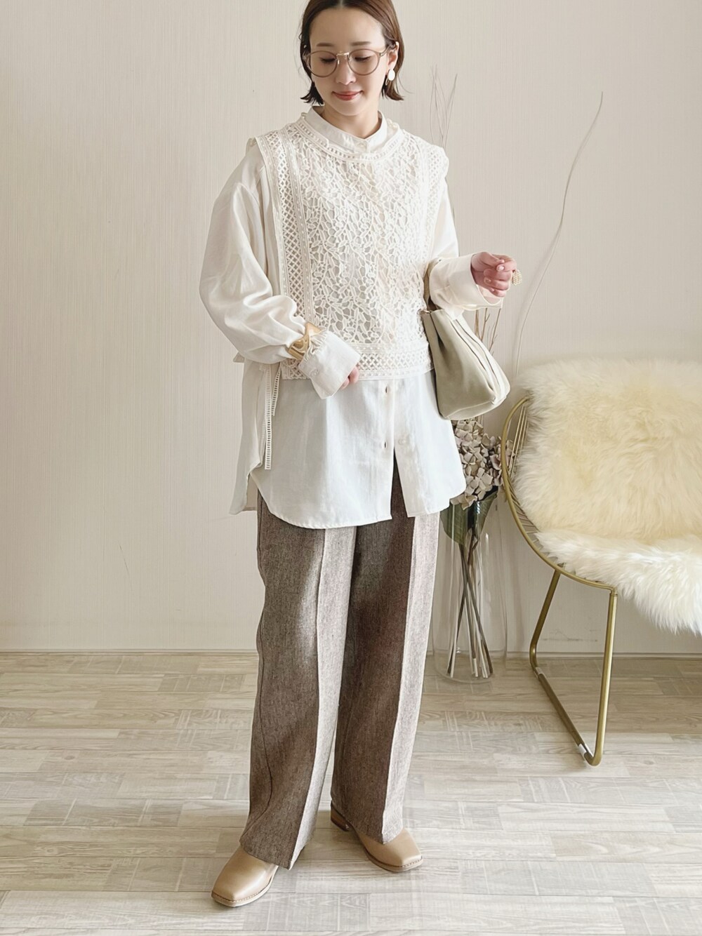 ホワイト系のトップス、ホワイト系のバッグ、ベージュ系のシューズを着用したレディースの冬コーディネートの1枚目の写真