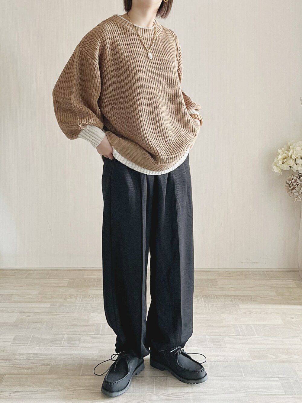 イエロー系のニット/セーター、ブラック系のパンツ、ホワイト系のシューズを着用したレディースの冬コーディネートの1枚目の写真