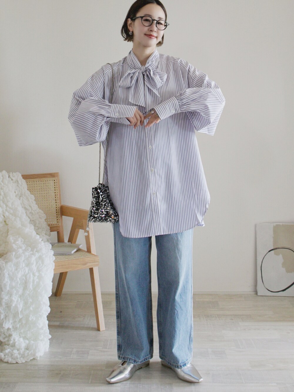 ホワイト系のシャツ/ブラウス、ブルー系のデニムパンツ、シルバー系のパンプスを着用したレディースの春コーディネートの1枚目の写真