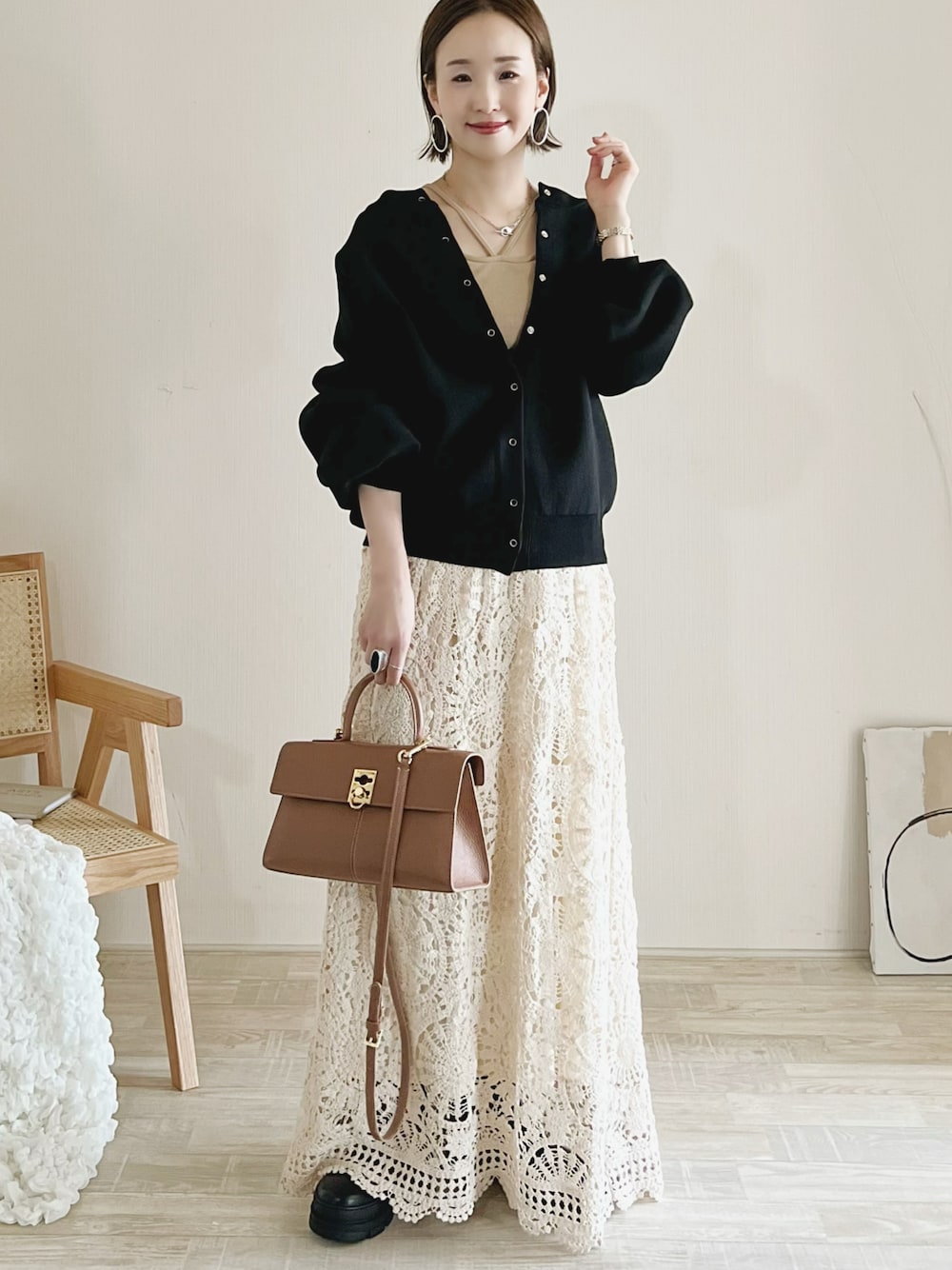 ブラック系のカーディガン/ボレロ、ホワイト系のトップス、ホワイト系のスカートを着用したレディースの秋コーディネートの1枚目の写真