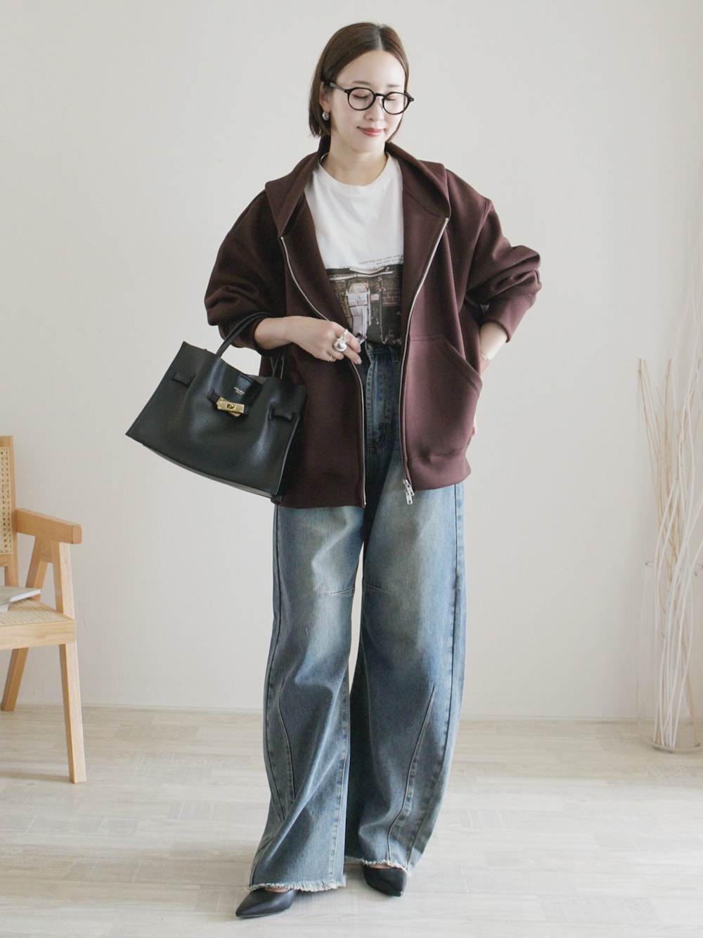 ブルー系のデニムパンツ、ブラウン系のパーカー、ホワイト系のTシャツ/カットソーを着用したレディースの秋コーディネートの1枚目の写真