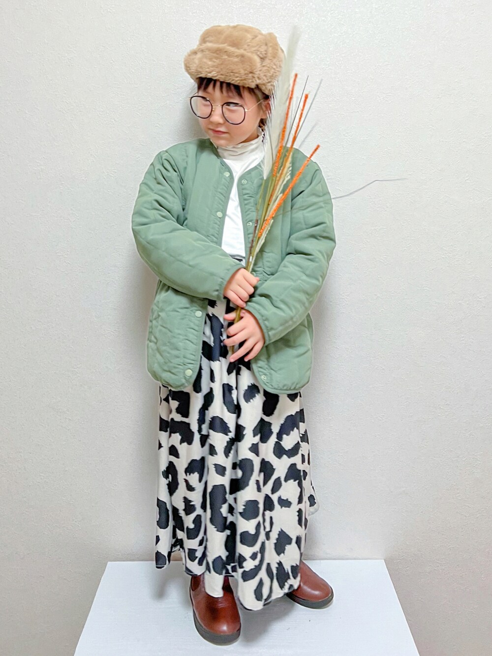 グリーン系のジャケット/アウター、ホワイト系のTシャツ/カットソー、ブラウン系のブーツを着用したキッズの秋コーディネートの1枚目の写真