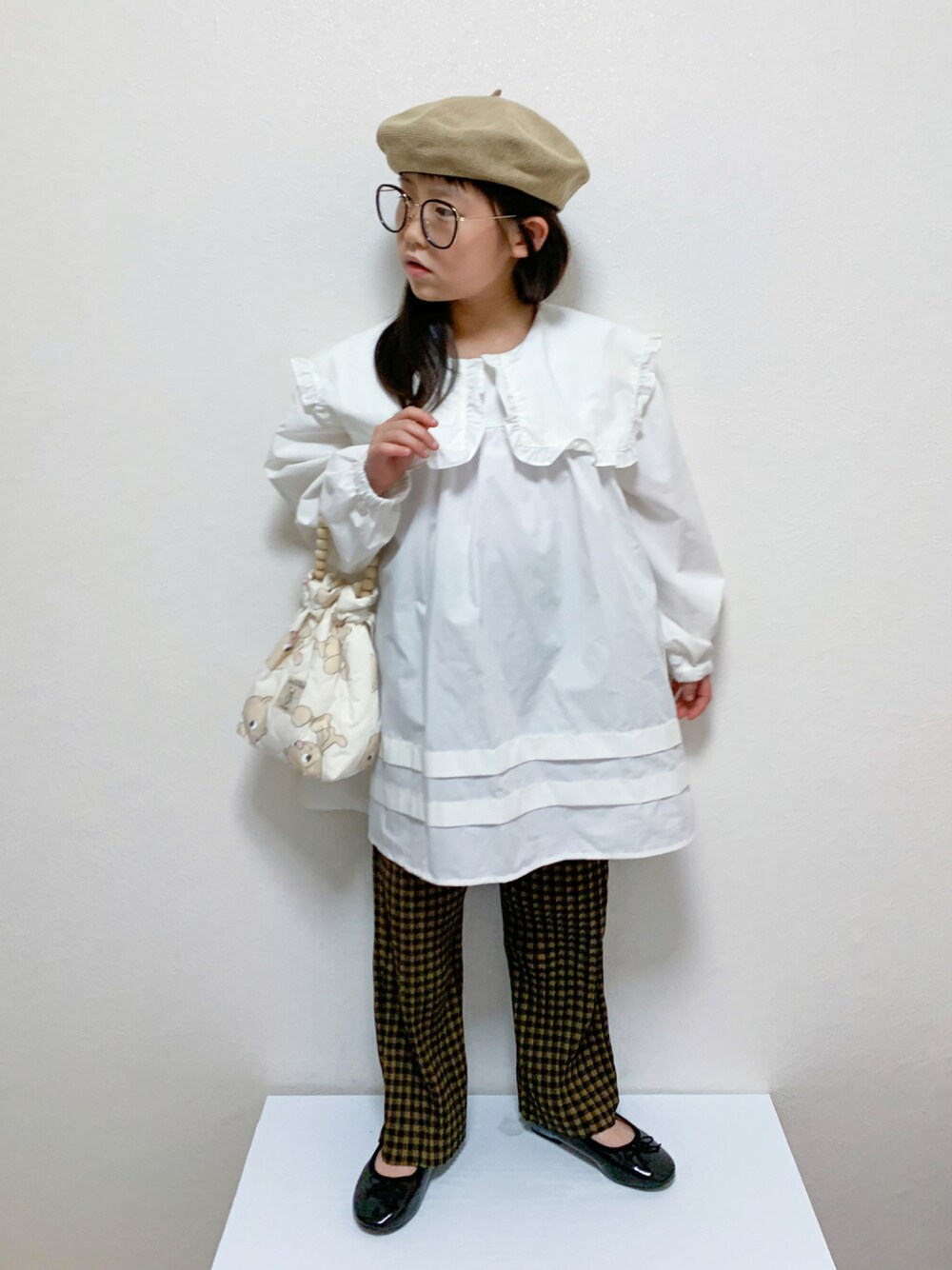 ブラウン系のその他パンツ、ブラック系のバレエシューズ、ホワイト系のシャツ/ブラウスを着用したキッズの秋コーディネートの1枚目の写真