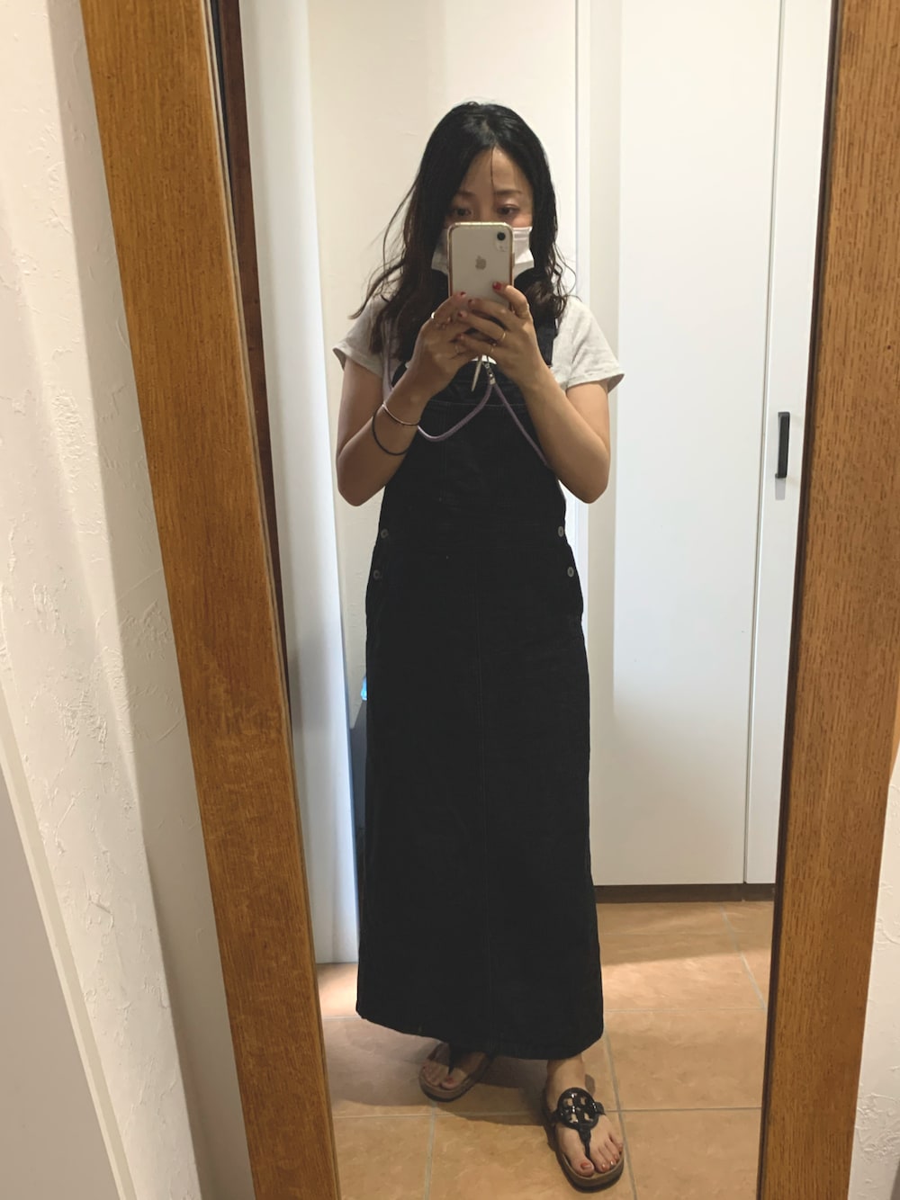 ブラック系のジャンパースカートを着用したレディースの夏コーディネートの1枚目の写真