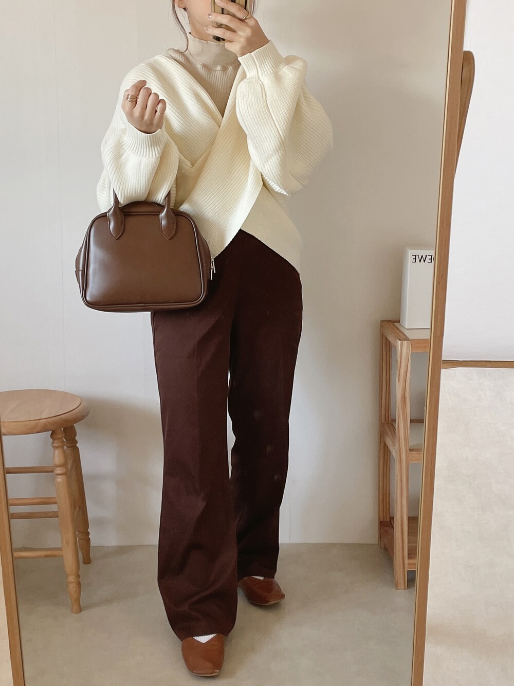 ホワイト系のニット/セーター、ブラウン系のボストンバッグ、ブラウン系のその他パンツを着用したレディースの秋コーディネートの1枚目の写真