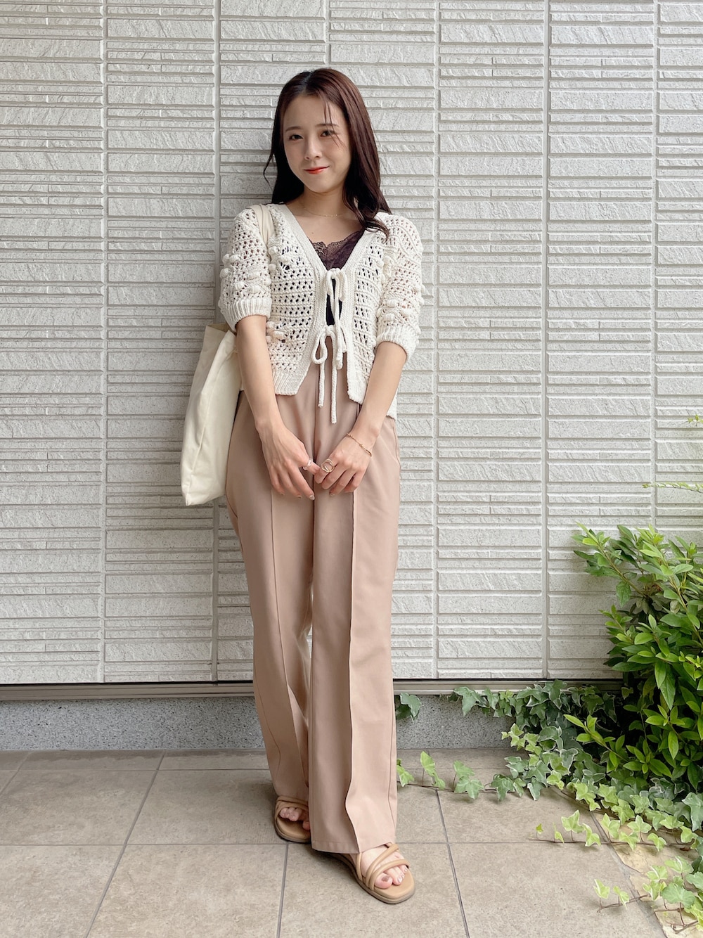 ベージュ系のサンダル、ホワイト系のトップスを着用したレディースの夏コーディネートの1枚目の写真