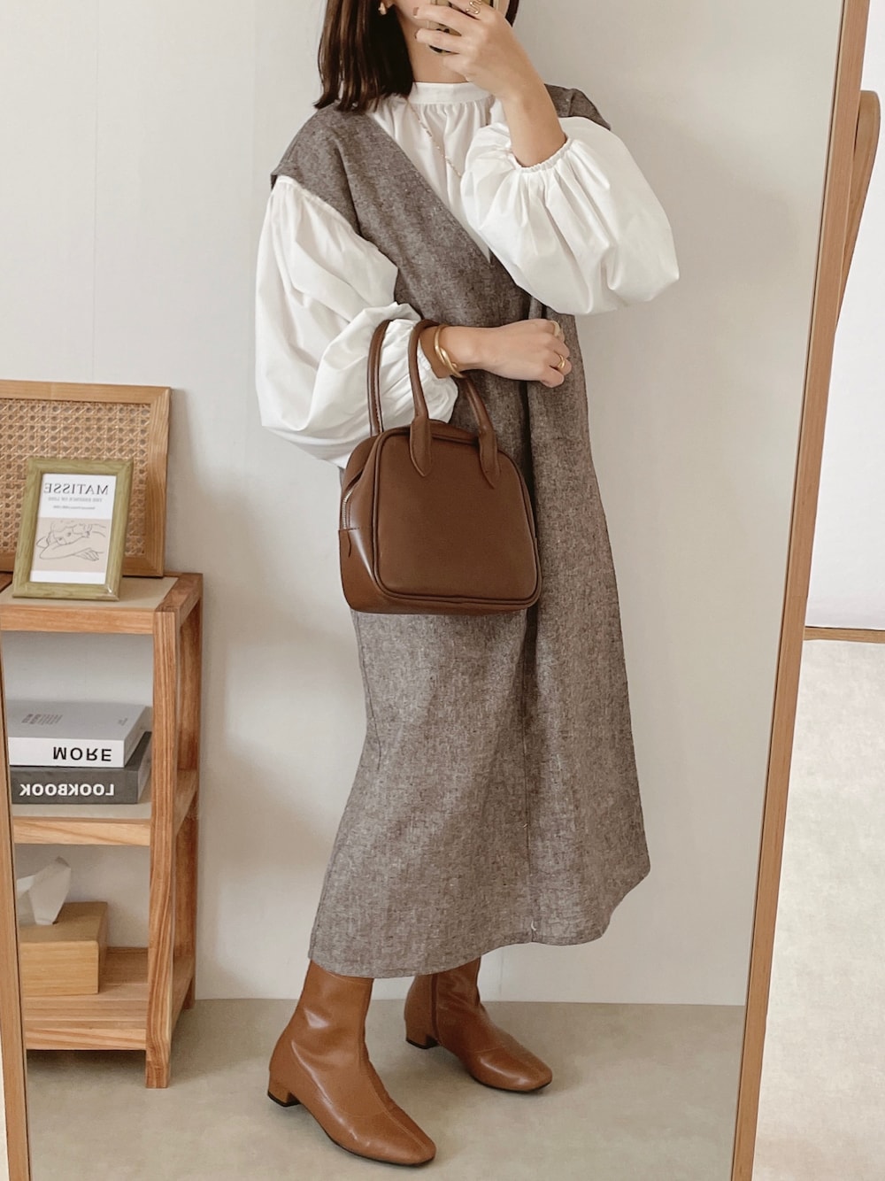 ホワイト系のシャツ/ブラウス、ブラウン系のボストンバッグ、ベージュ系のブーツを着用したレディースの秋コーディネートの1枚目の写真