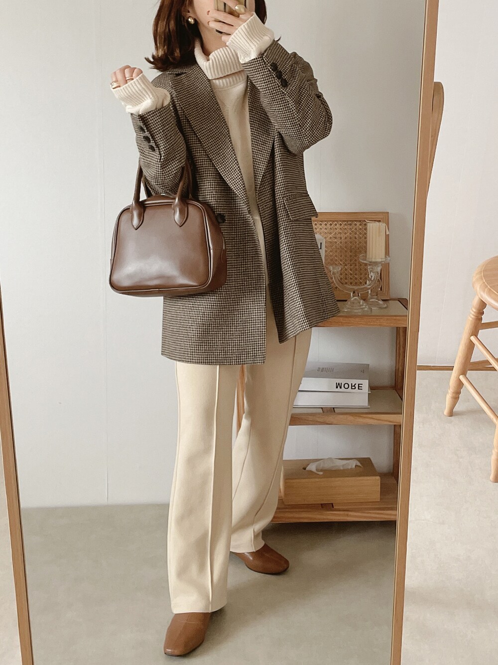 ブラウン系のテーラードジャケット、ブラウン系のボストンバッグ、ホワイト系のその他パンツを着用したレディースの秋コーディネートの1枚目の写真