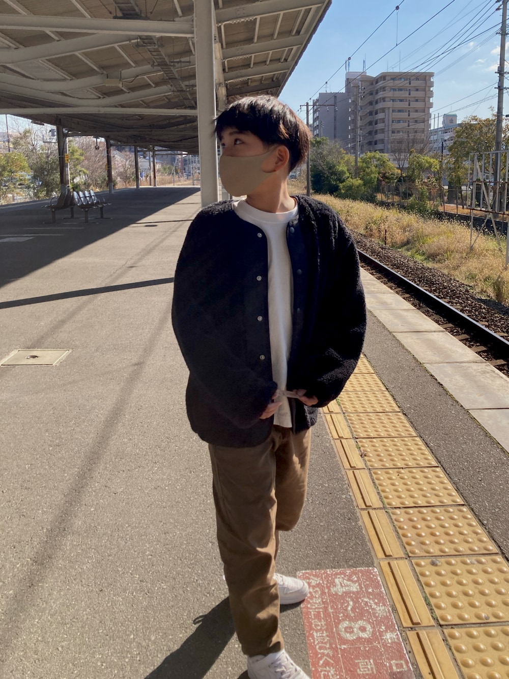 ブラック系のジャケット/アウター、ホワイト系のスニーカー、ブラウン系のパンツを着用したキッズの冬コーディネートの1枚目の写真