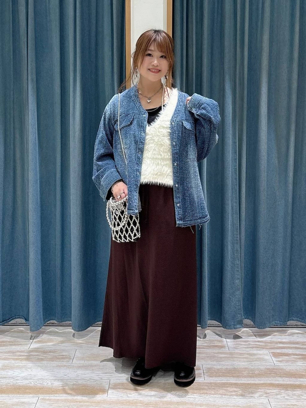 シルバー系のショルダーバッグ、ブルー系のシャツ/ブラウス、ブラウン系のスカートを着用したレディースの秋コーディネートの1枚目の写真