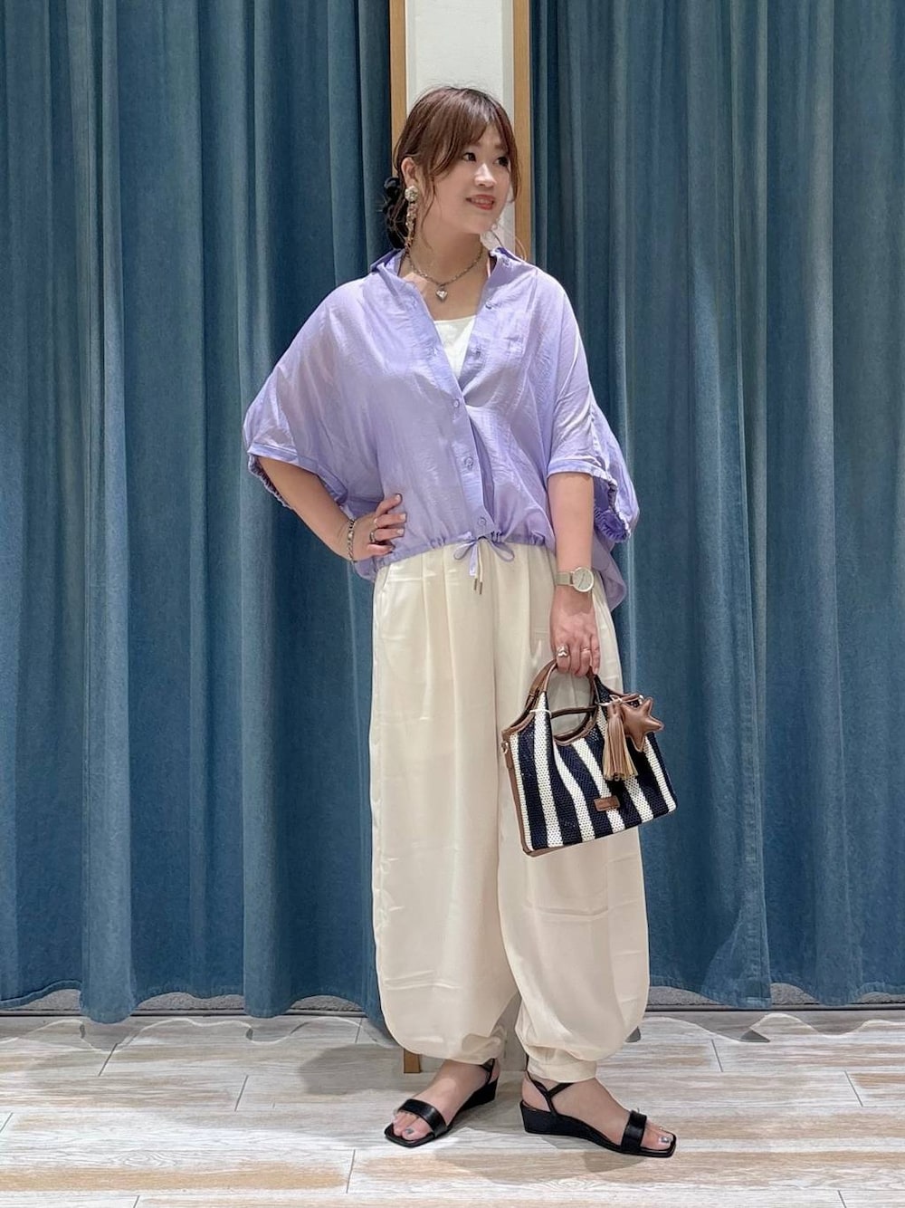 ベージュ系のその他パンツ、ブルー系のショルダーバッグ、ブラック系のサンダルを着用したレディースの夏コーディネートの1枚目の写真