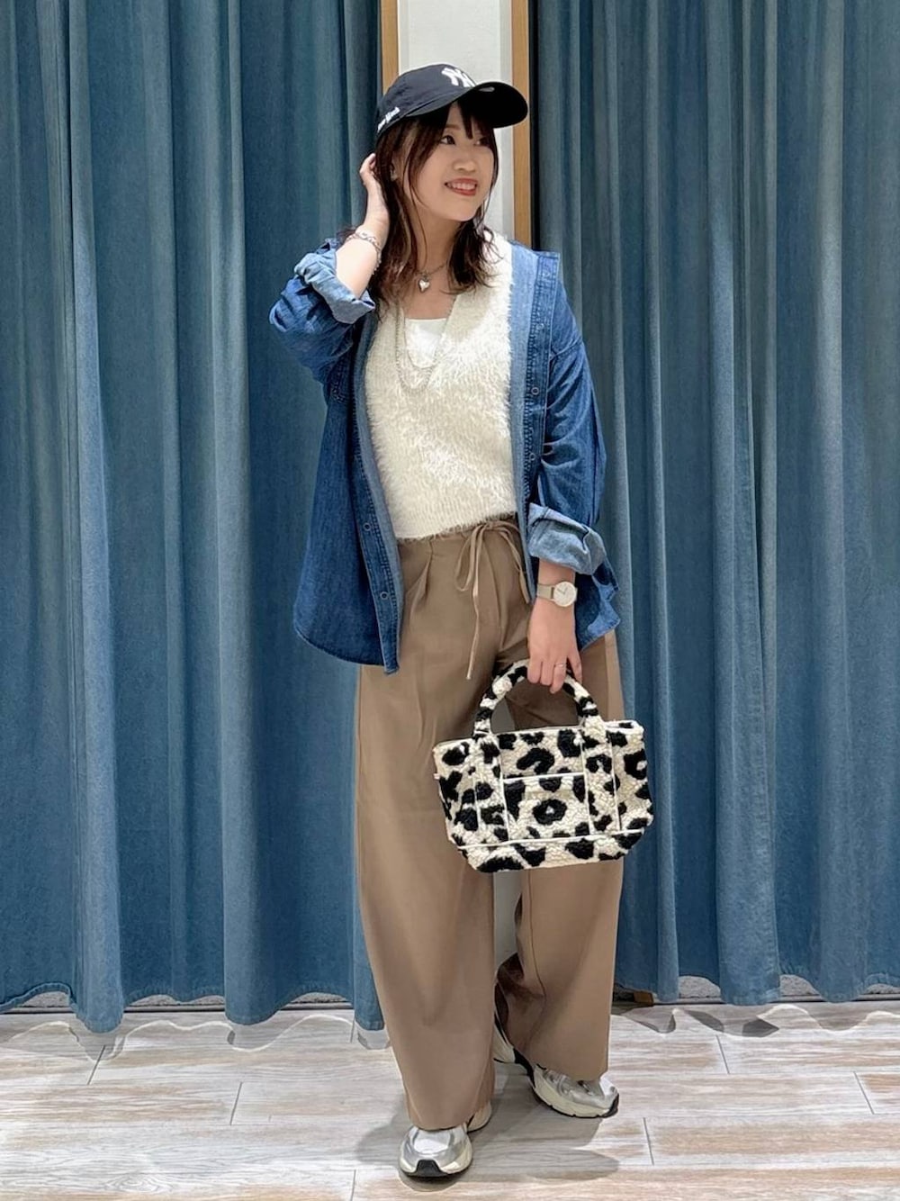 ブルー系のシャツ/ブラウス、ホワイト系のベスト、ベージュ系のトートバッグを着用したレディースの秋コーディネートの1枚目の写真