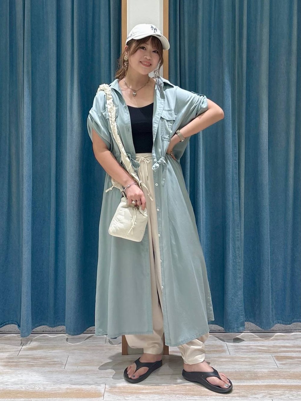 ベージュ系のその他パンツ、ブラック系のサンダル、ホワイト系のショルダーバッグを着用したレディースの夏コーディネートの1枚目の写真