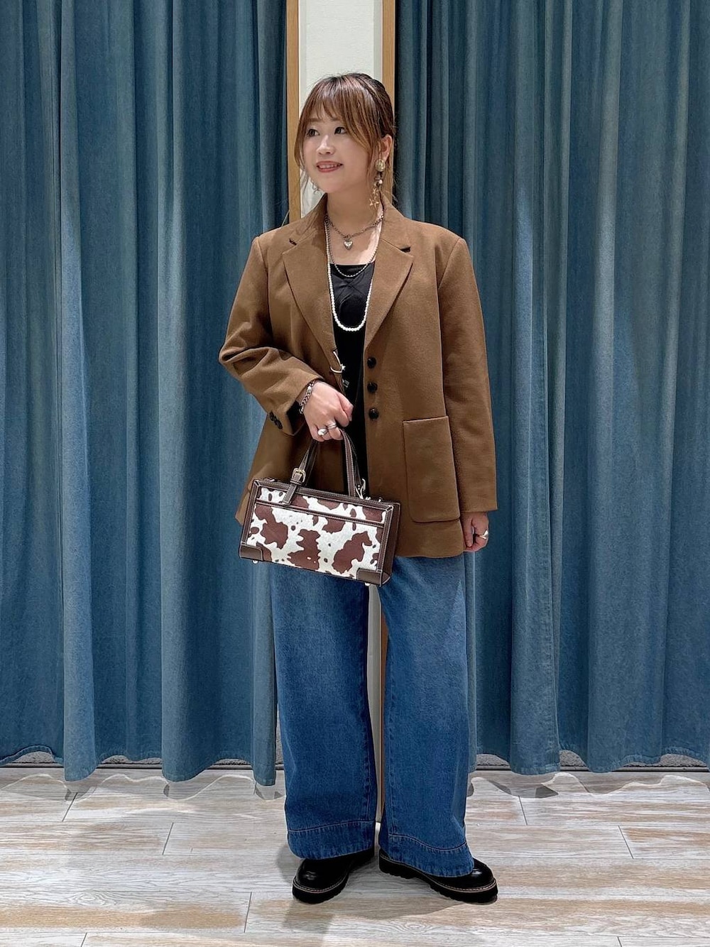 ブルー系のその他パンツ、その他のショルダーバッグ、ブラウン系のテーラードジャケットを着用したレディースの秋コーディネートの1枚目の写真