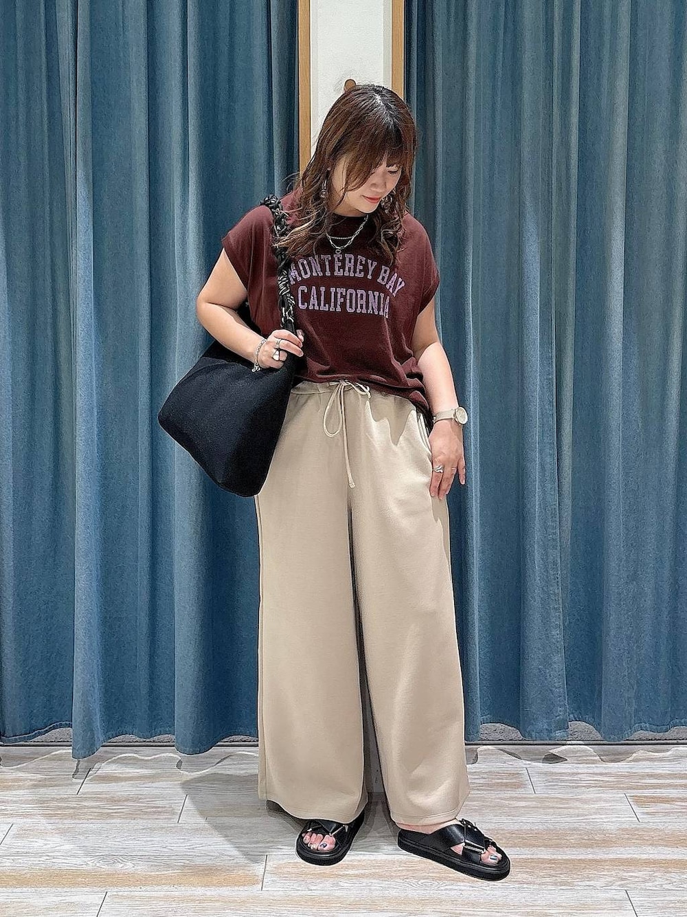 ブラウン系のTシャツ/カットソー、ブラック系のサンダル、ブラック系のトートバッグを着用したレディースの夏コーディネートの1枚目の写真