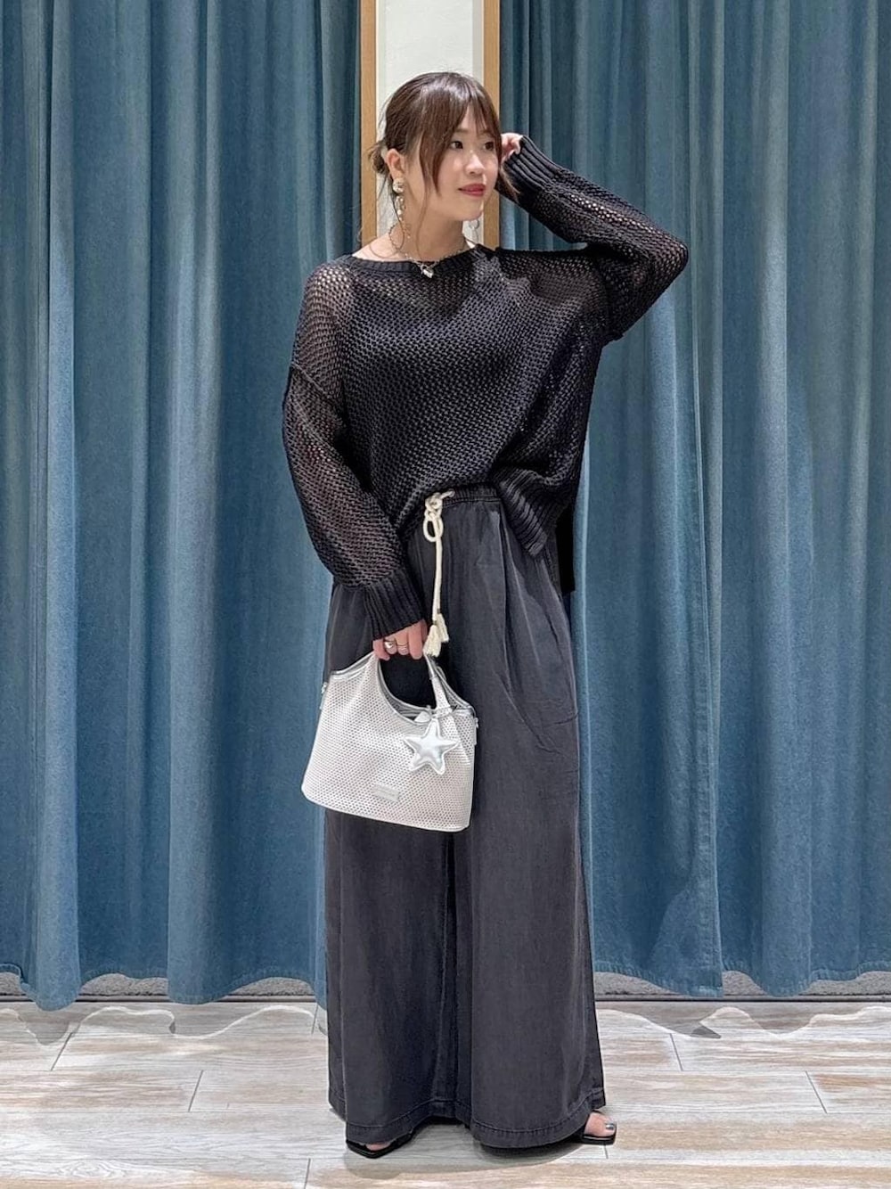 ブラック系のデニムパンツ、グレー系のショルダーバッグ、ブラック系のサンダルを着用したレディースの春コーディネートの1枚目の写真