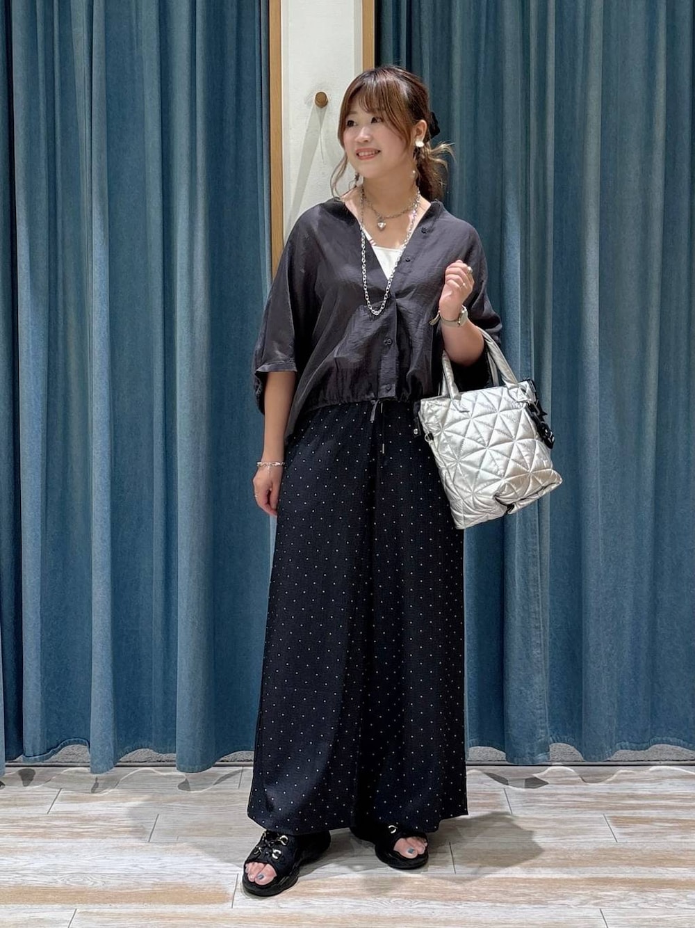 ブラック系のサンダル、グレー系のシャツ/ブラウス、シルバー系のトートバッグを着用したレディースの夏コーディネートの1枚目の写真