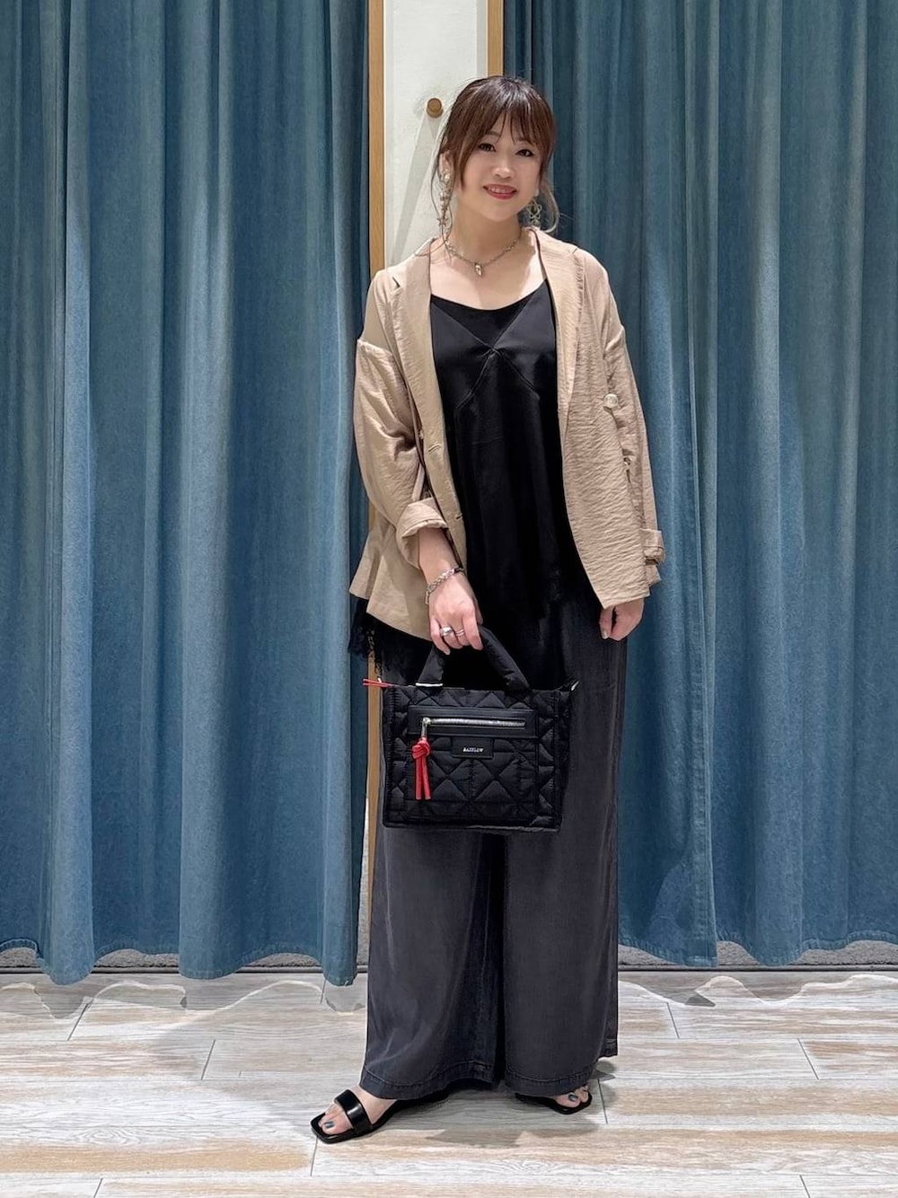 ブラック系のショルダーバッグ、ブラック系のデニムパンツ、ブラック系のキャミソールを着用したレディースの春コーディネートの1枚目の写真