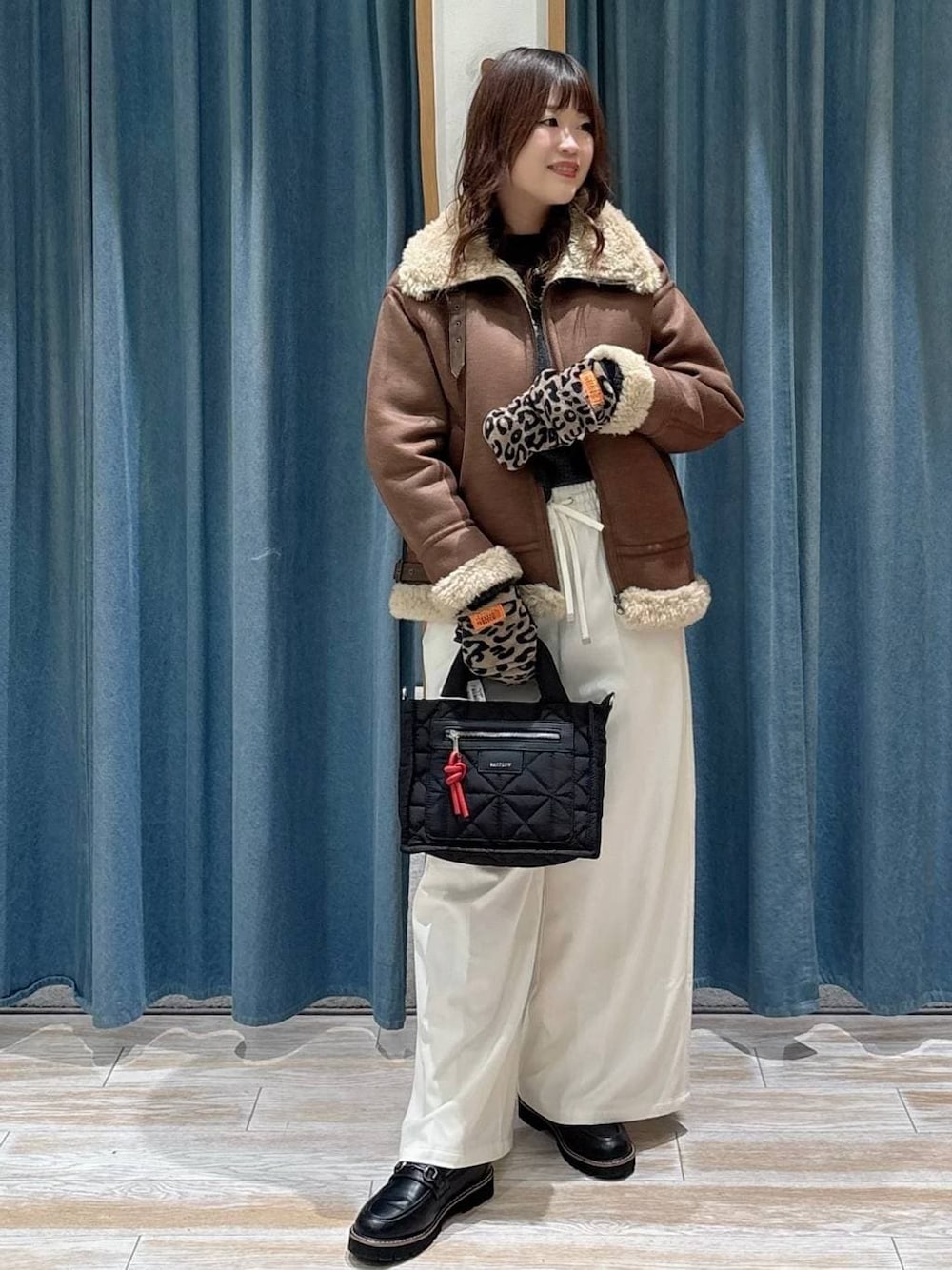 ブラック系のショルダーバッグ、ベージュ系のその他パンツ、グレー系のニット/セーターを着用したレディースの秋コーディネートの1枚目の写真