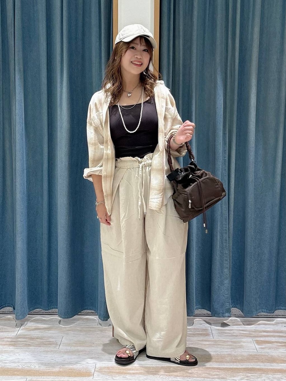 ホワイト系のその他パンツ、その他のサンダル、ブラウン系のショルダーバッグを着用したレディースの夏コーディネートの1枚目の写真