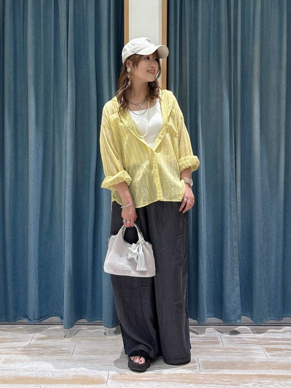 イエロー系のシャツ/ブラウス、ブラック系のデニムパンツ、グレー系のショルダーバッグを着用したレディースの夏コーディネートの1枚目の写真