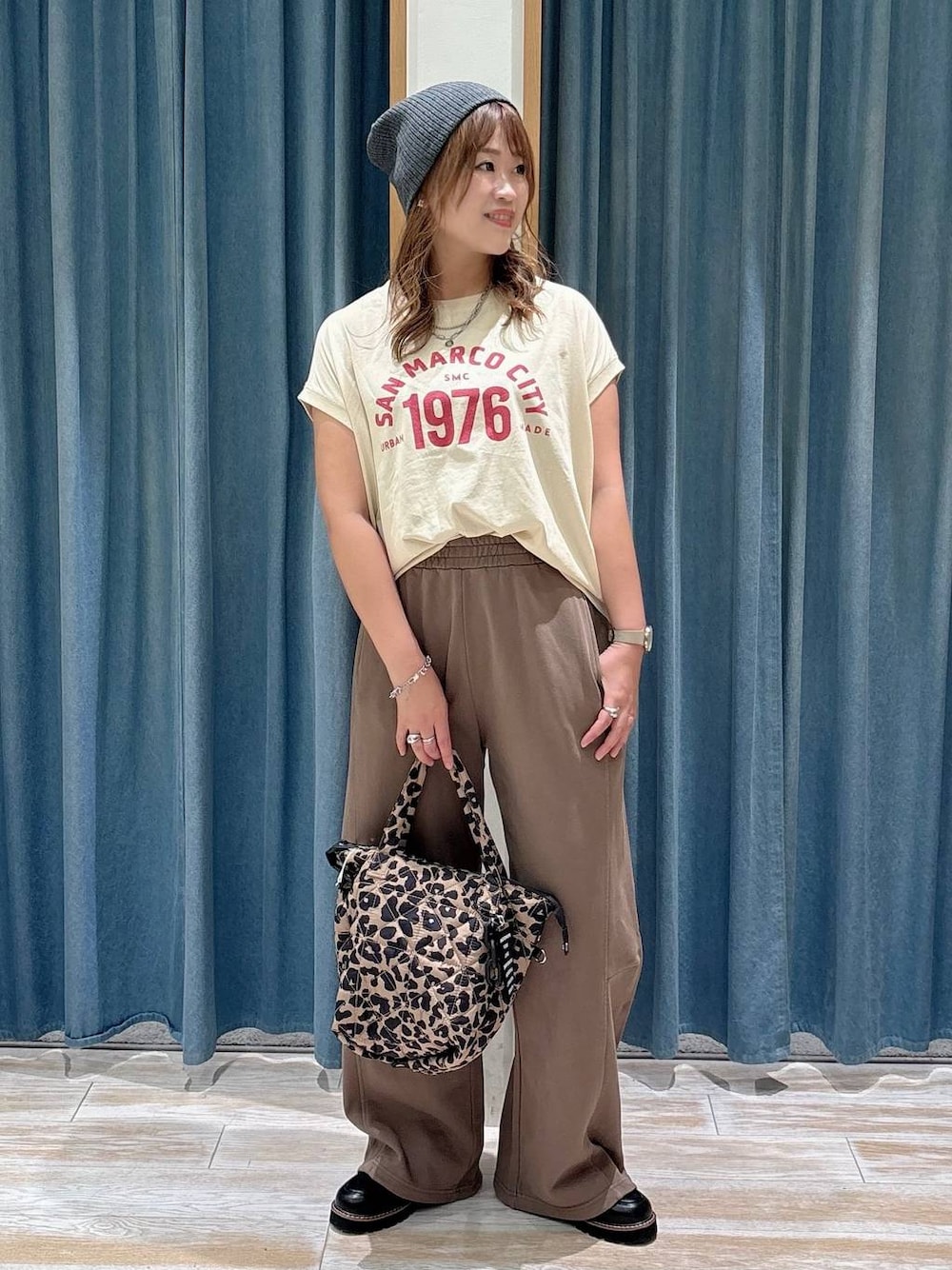ベージュ系のTシャツ/カットソー、ブラック系のローファー、その他のトートバッグを着用したレディースの夏コーディネートの1枚目の写真