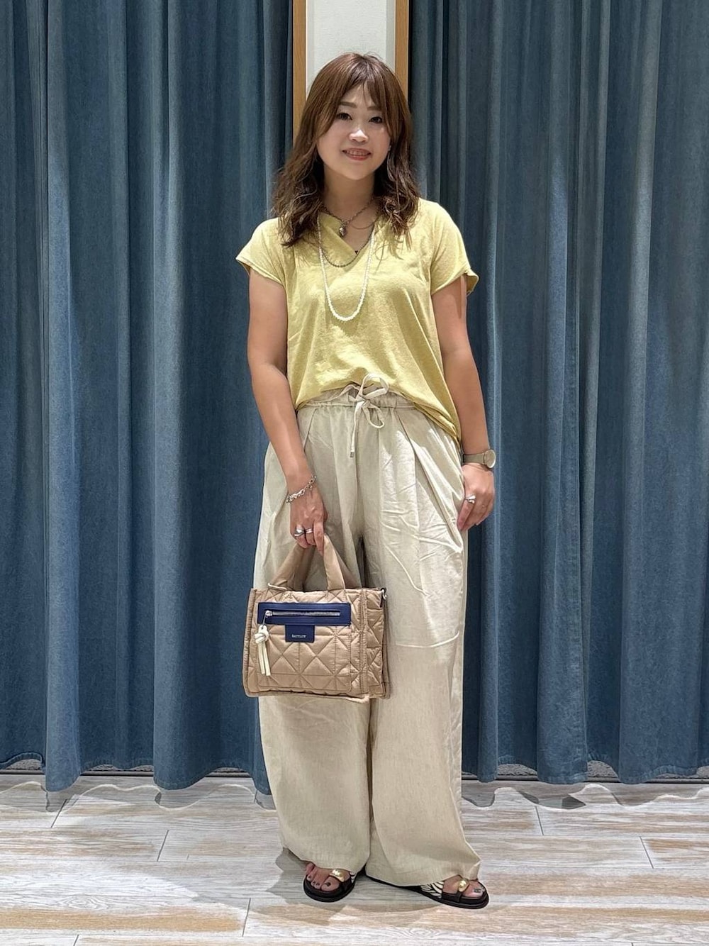 ベージュ系のショルダーバッグ、ベージュ系のその他パンツ、その他のサンダルを着用したレディースの夏コーディネートの1枚目の写真
