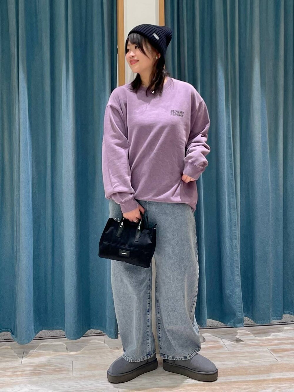 パープル系のスウェット、グレー系のブーツ、ブルー系のデニムパンツを着用したレディースの冬コーディネートの1枚目の写真