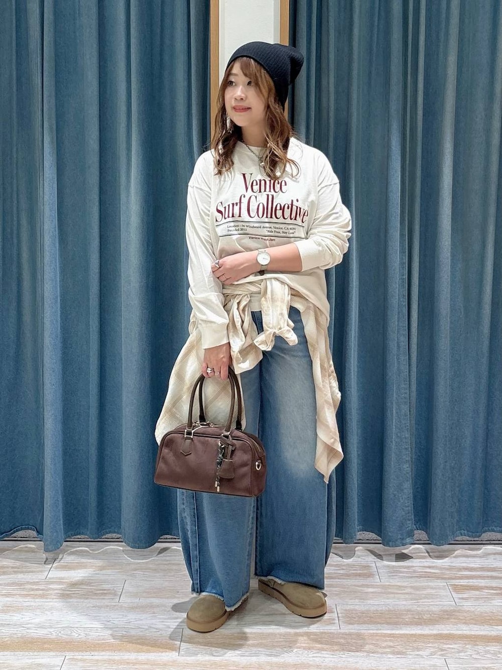 ベージュ系のその他シューズ、ブルー系のデニムパンツ、ブラウン系のハンドバッグを着用したレディースの秋コーディネートの1枚目の写真