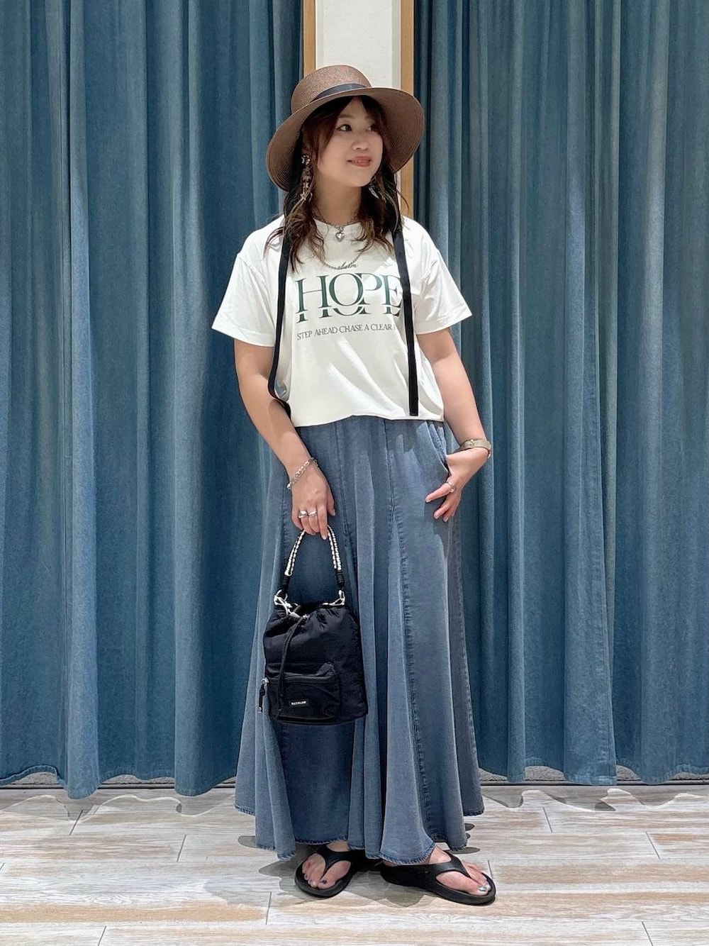 ホワイト系のTシャツ/カットソー、ブラック系のショルダーバッグ、ブルー系のスカートを着用したレディースの夏コーディネートの1枚目の写真