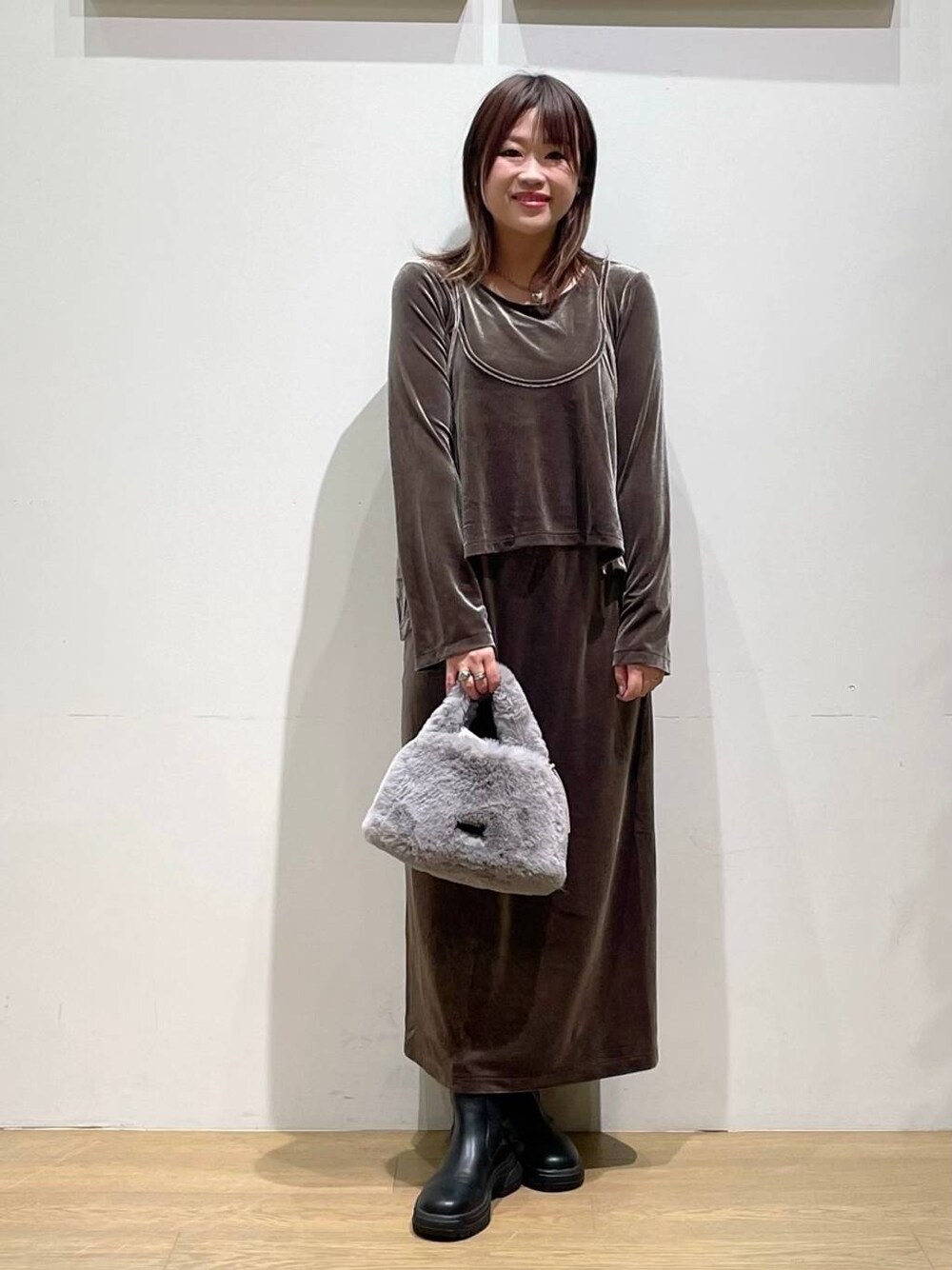 ブラック系のブーツ、グレー系のショルダーバッグ、グリーン系のワンピースを着用したレディースの秋コーディネートの1枚目の写真