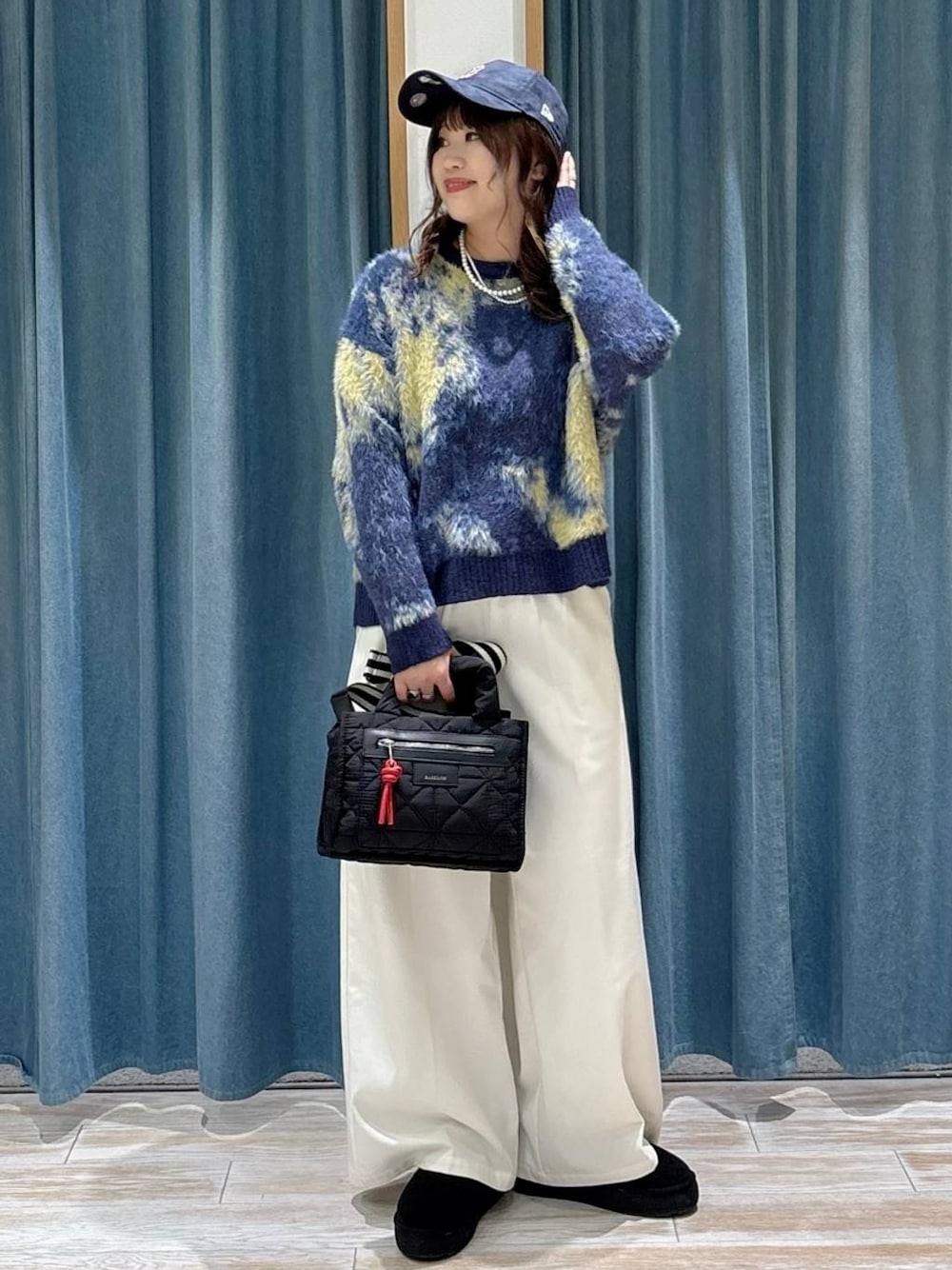 ブラック系のショルダーバッグ、ベージュ系のその他パンツ、ブラック系のブーツを着用したレディースの秋コーディネートの1枚目の写真