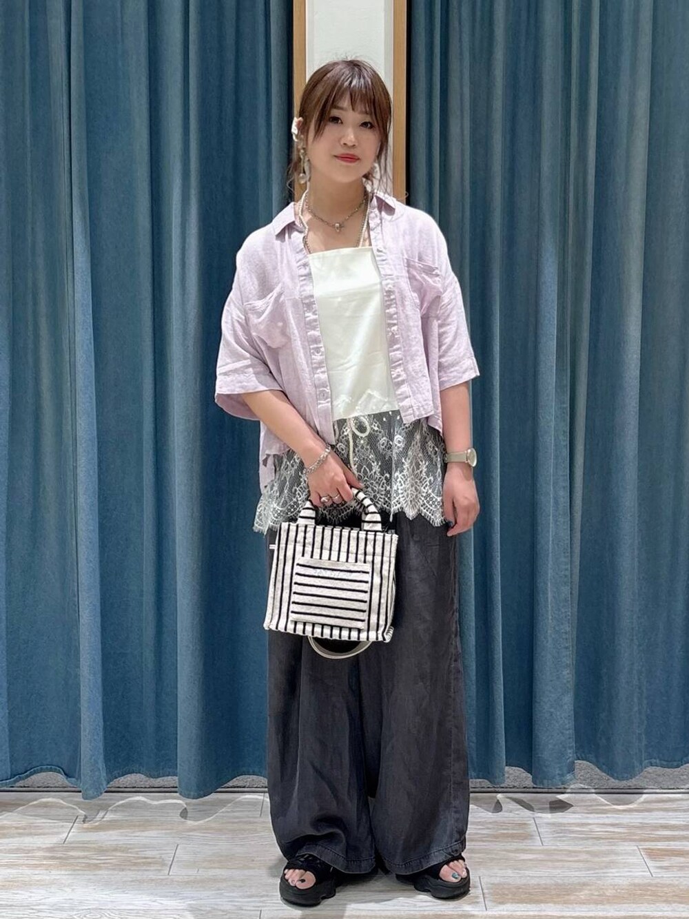 ブラック系のデニムパンツ、ベージュ系のトートバッグ、パープル系のシャツ/ブラウスを着用したレディースの春コーディネートの1枚目の写真