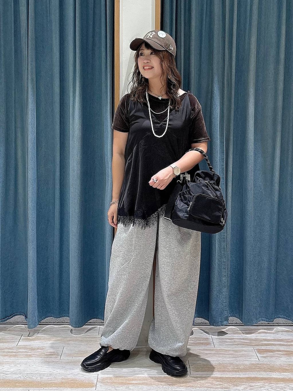 ブラック系のスニーカー、グレー系のスウェットパンツ、ブラウン系のTシャツ/カットソーを着用したレディースの夏コーディネートの1枚目の写真