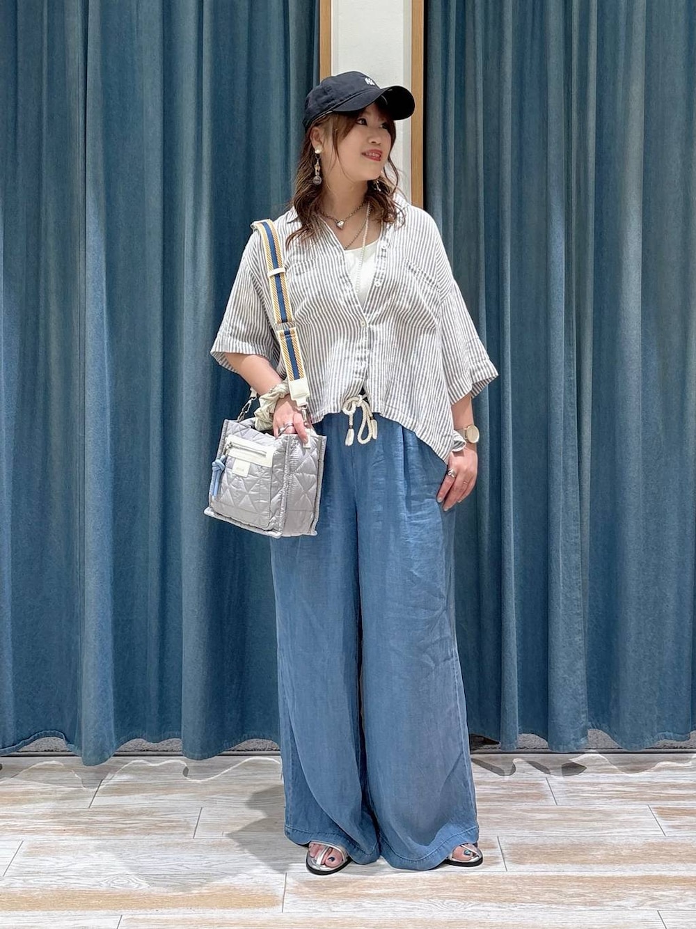グレー系のショルダーバッグ、ブルー系のデニムパンツ、グレー系のシャツ/ブラウスを着用したレディースの春コーディネートの1枚目の写真