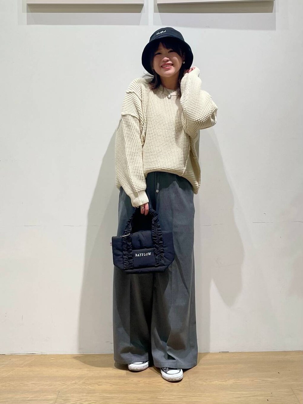 グレー系のその他パンツ、ブラック系のトートバッグ、ホワイト系のニット/セーターを着用したレディースの秋コーディネートの1枚目の写真