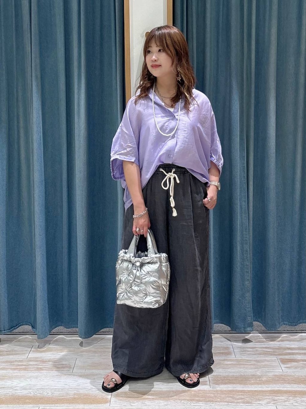 ブラック系のデニムパンツ、シルバー系のショルダーバッグ、ブラック系のサンダルを着用したレディースの夏コーディネートの1枚目の写真