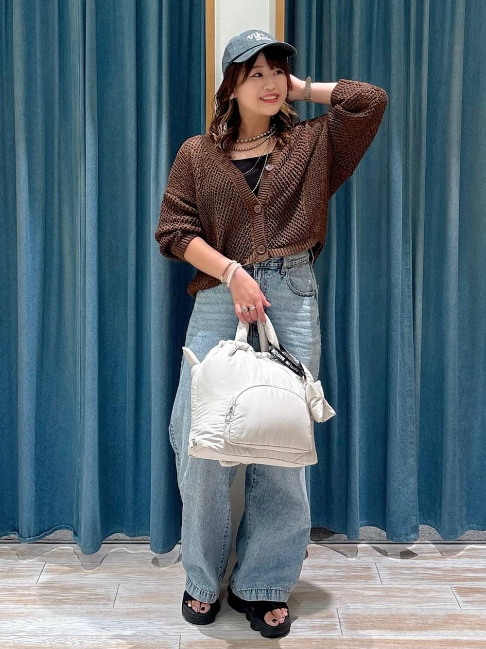 ブラック系のキャミソール、ブルー系のデニムパンツ、ホワイト系のトートバッグを着用したレディースの夏コーディネートの1枚目の写真