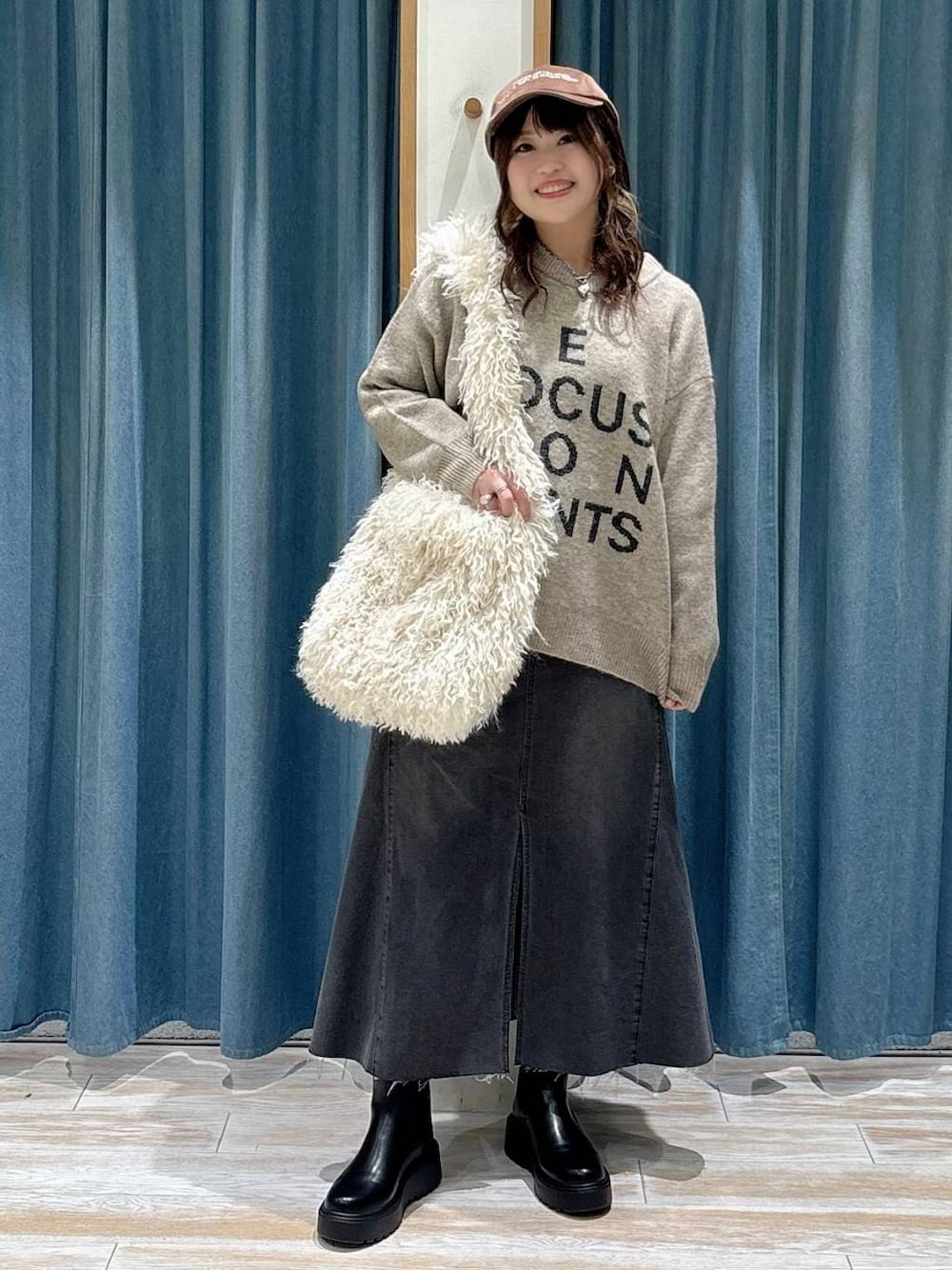 ブラック系のブーツ、ベージュ系のショルダーバッグ、ブラック系のスカートを着用したレディースの秋コーディネートの1枚目の写真