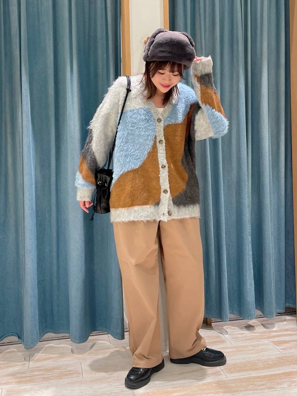 ブラック系のショルダーバッグ、ベージュ系のその他パンツ、グレー系のカーディガン/ボレロを着用したレディースの冬コーディネートの1枚目の写真