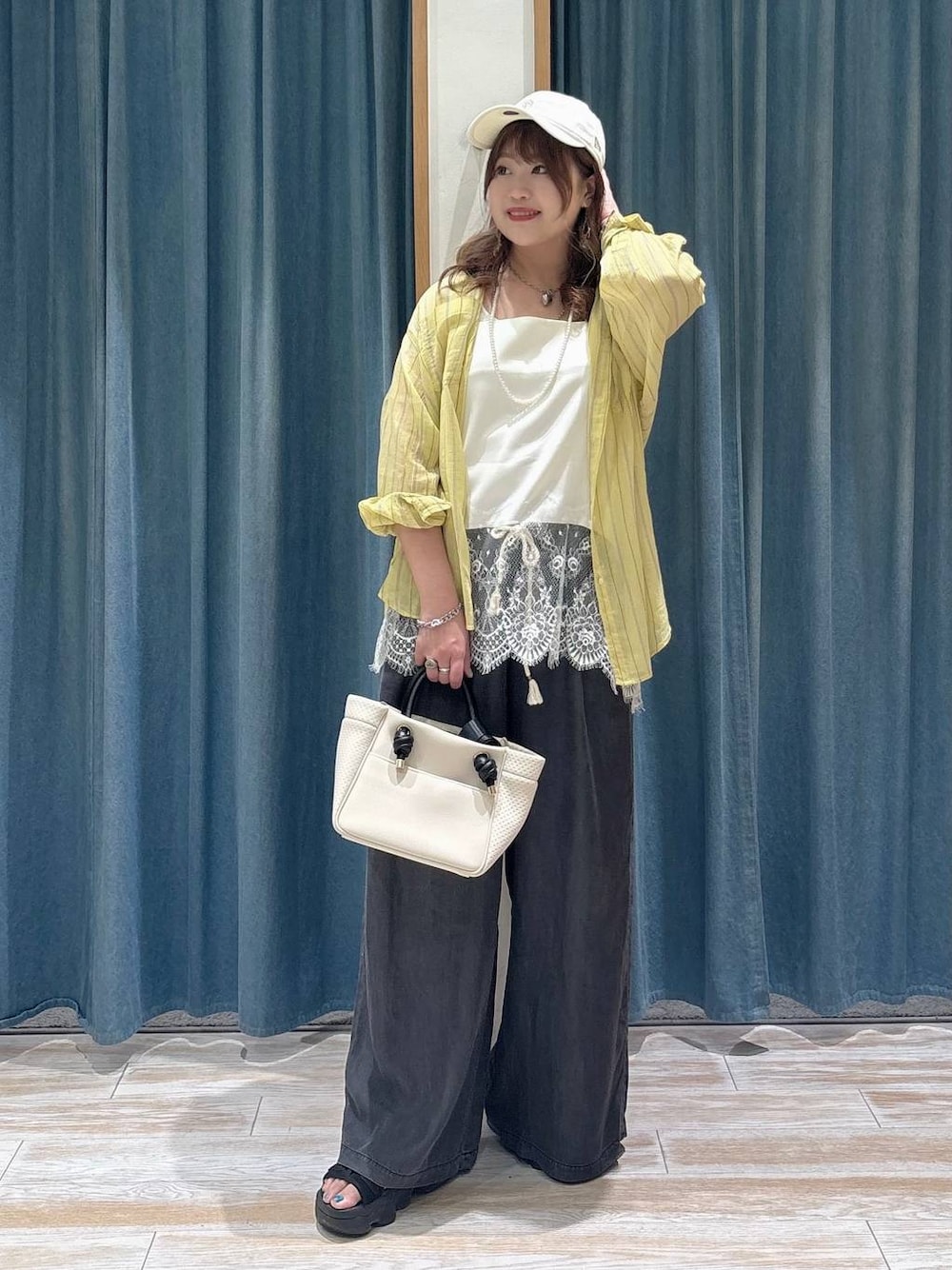 イエロー系のシャツ/ブラウス、ブラック系のデニムパンツ、ホワイト系のキャミソールを着用したレディースの春コーディネートの1枚目の写真