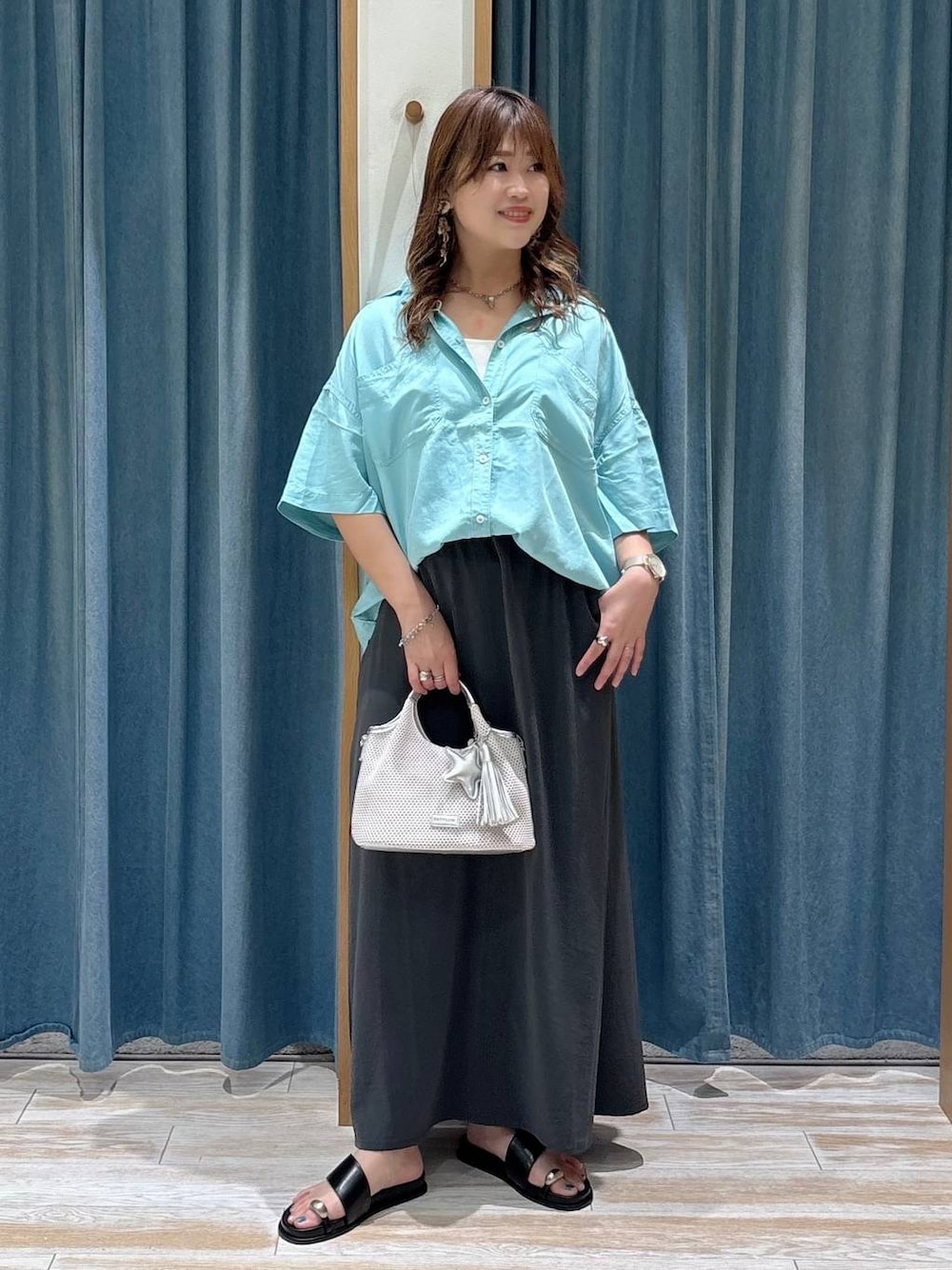 ブルー系のシャツ/ブラウス、グレー系のショルダーバッグ、ブラック系のサンダルを着用したレディースの夏コーディネートの1枚目の写真
