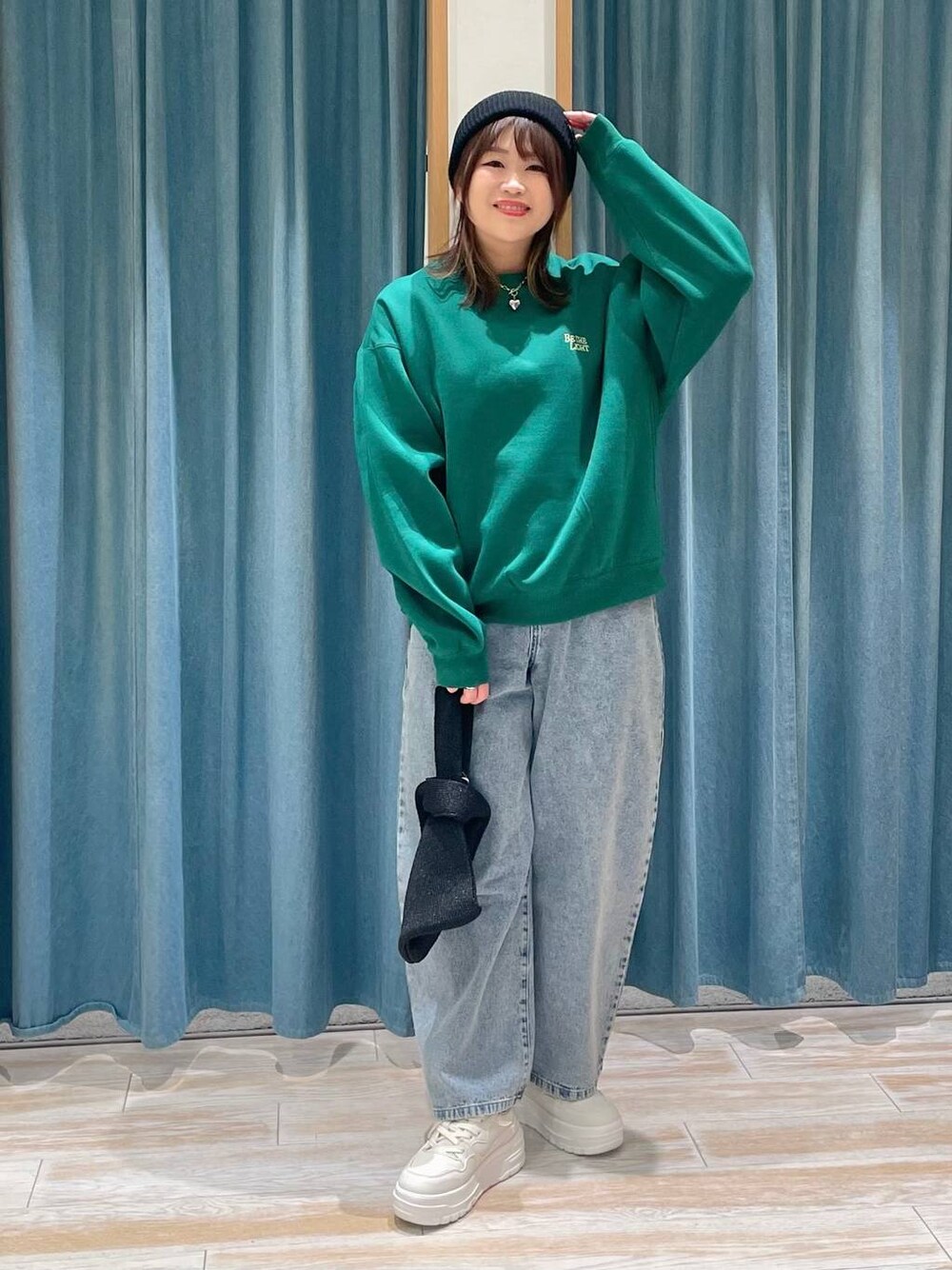 ホワイト系のスニーカー、ブルー系のデニムパンツ、ブラック系のハンドバッグを着用したレディースの冬コーディネートの1枚目の写真