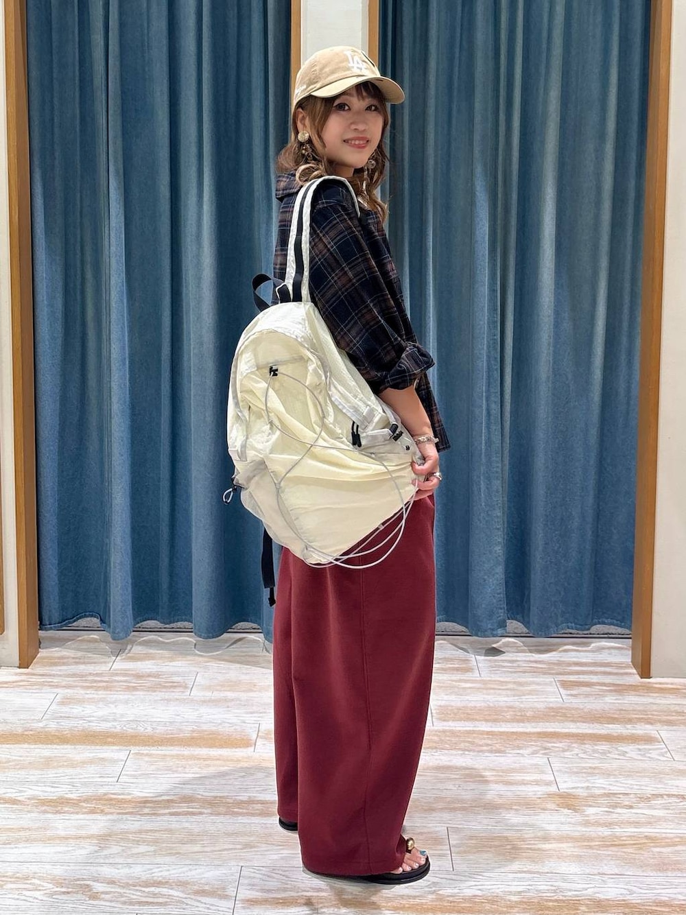 レッド系のスウェットパンツ、ホワイト系のバックパック/リュック、その他のサンダルを着用したレディースの夏コーディネートの1枚目の写真