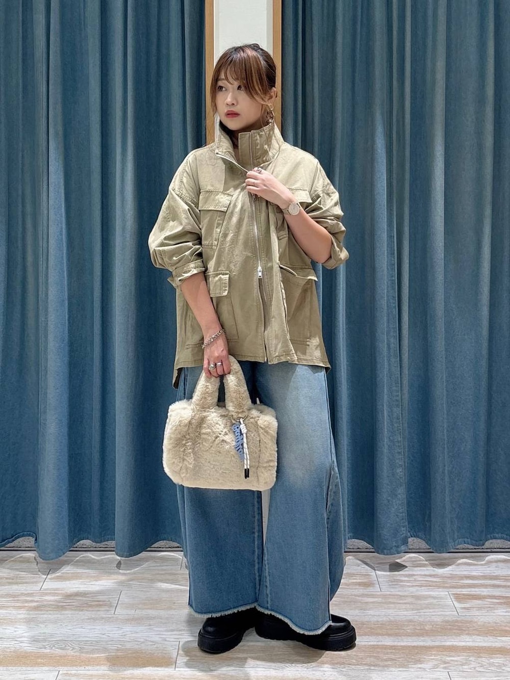 ブルー系のデニムパンツ、ベージュ系のトートバッグ、ベージュ系のブルゾンを着用したレディースの秋コーディネートの1枚目の写真