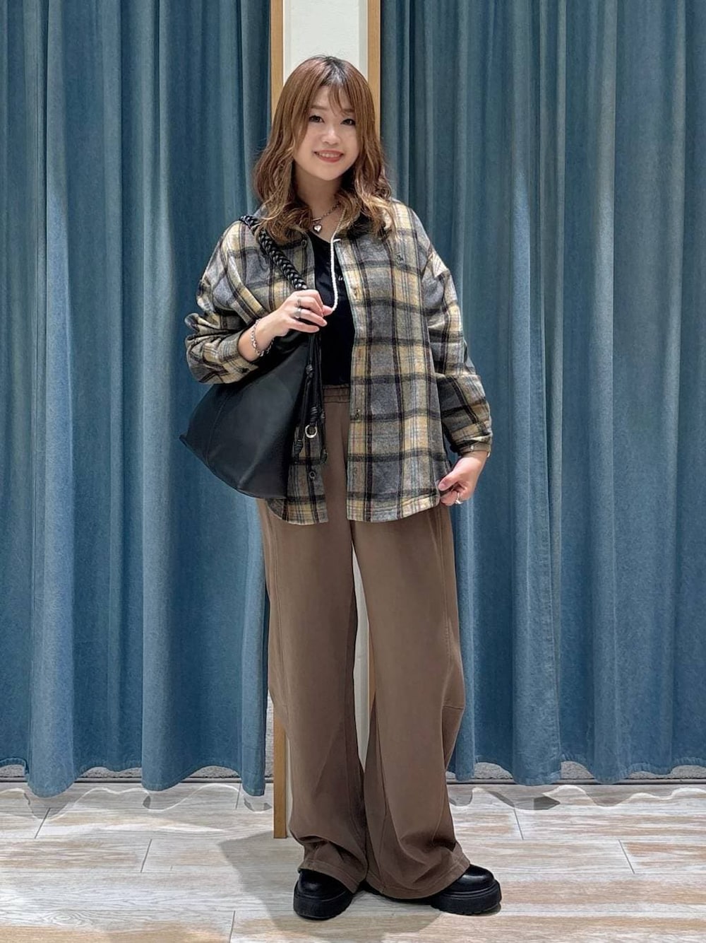 ブラウン系のスウェットパンツ、ブラック系のブーツ、イエロー系のシャツ/ブラウスを着用したレディースの秋コーディネートの1枚目の写真