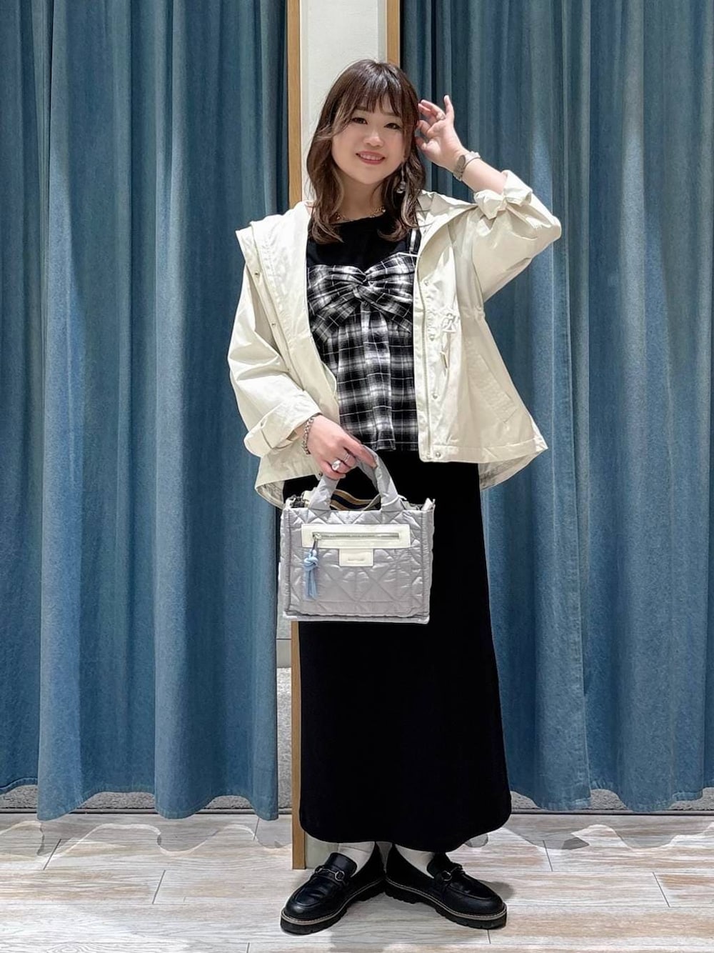 グレー系のショルダーバッグ、ホワイト系のマウンテンパーカー、ブラック系のローファーを着用したレディースの春コーディネートの1枚目の写真