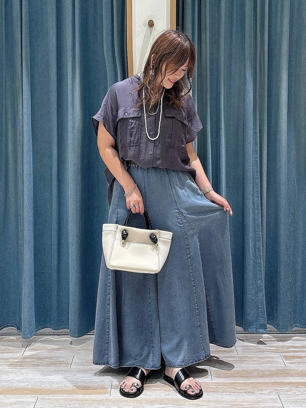 グレー系のシャツ/ブラウス、ブラック系のサンダル、ブルー系のスカートを着用したレディースの夏コーディネートの1枚目の写真