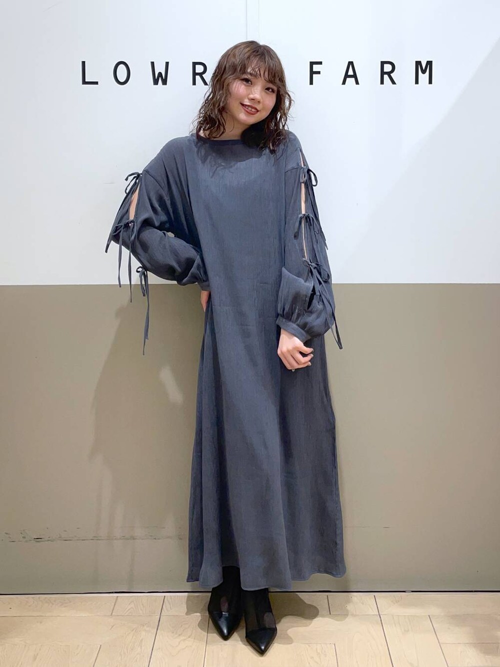 ブラック系のブーツ、グレー系のワンピースを着用したレディースの春コーディネートの1枚目の写真